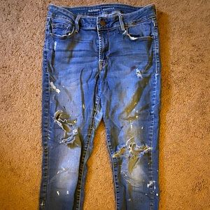 Blue ripped jeans with white paint splatters